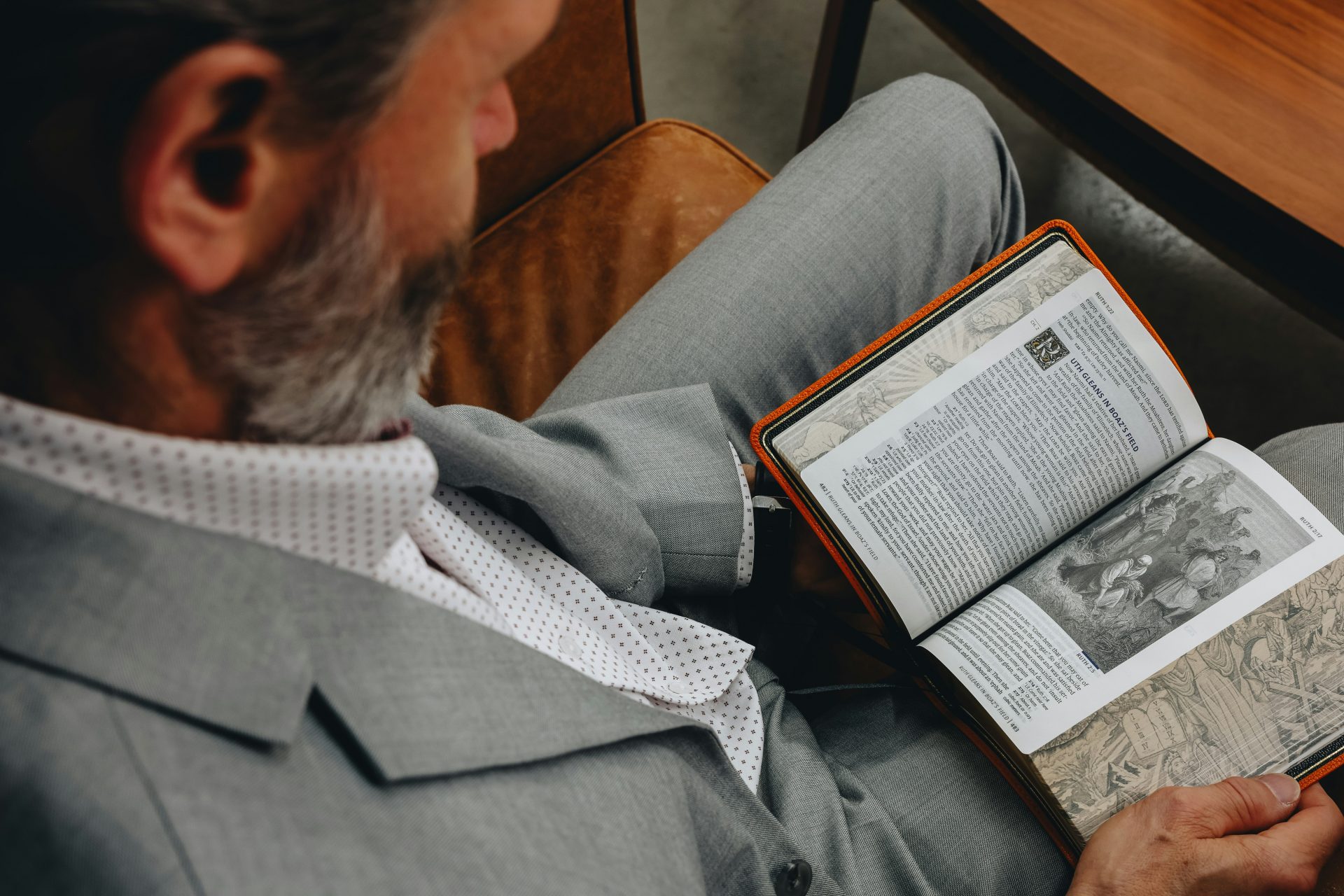 A man sitting in a chair reading a book