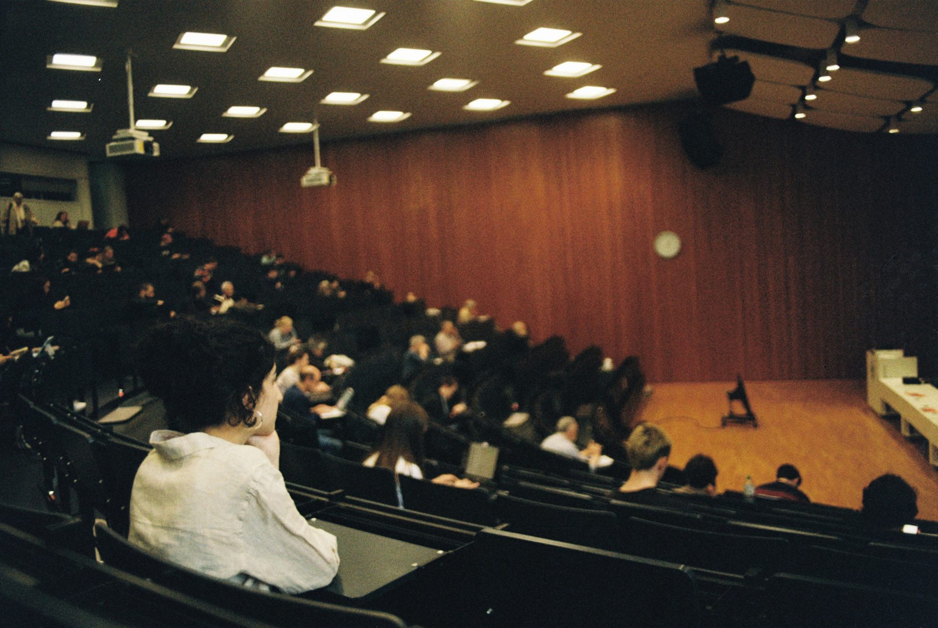 People attend a lecture in a large auditorium.